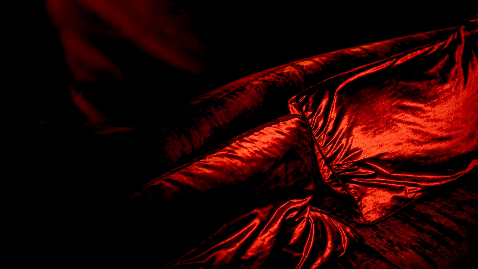 Deep red velvet cushions catching candlelight